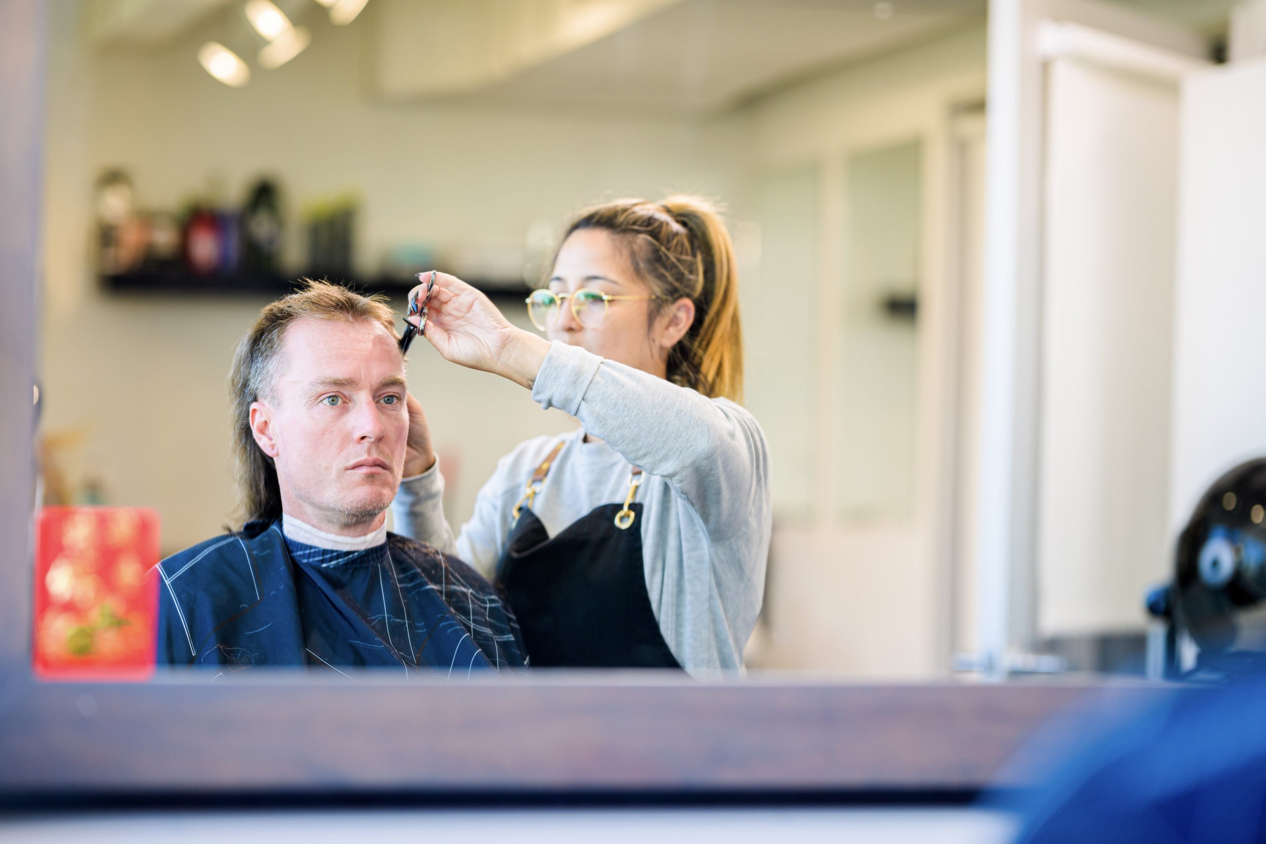 A mirror shot of Shane sitting in a barbershop getting a fresh haircut, which was one of the retreat activities for the Forge men.