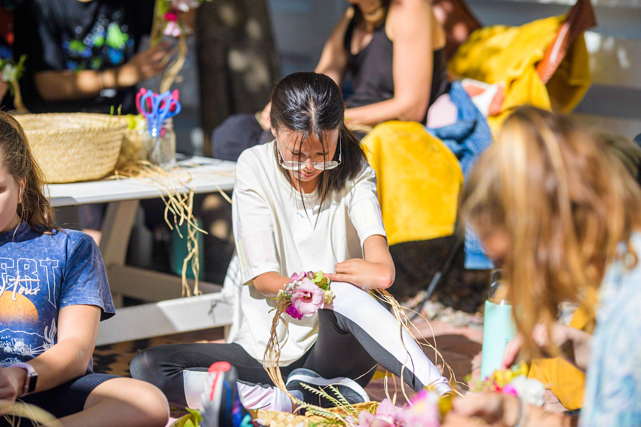 Beautifully Flawed attendee making a haku lei