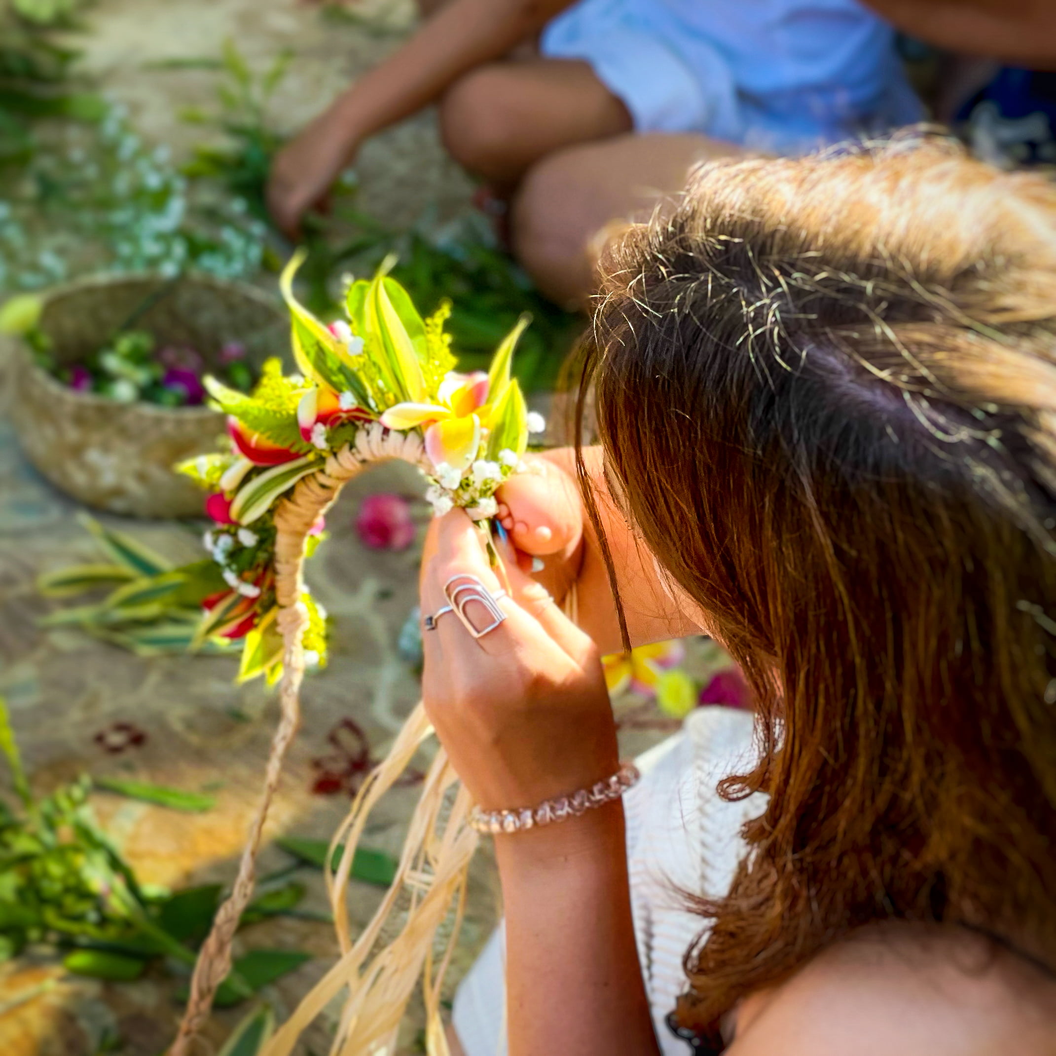 Beautifully Flawed Retreat Attendee Kasyn working on her haku lei while wearing her Mae Cargo rainbow ring