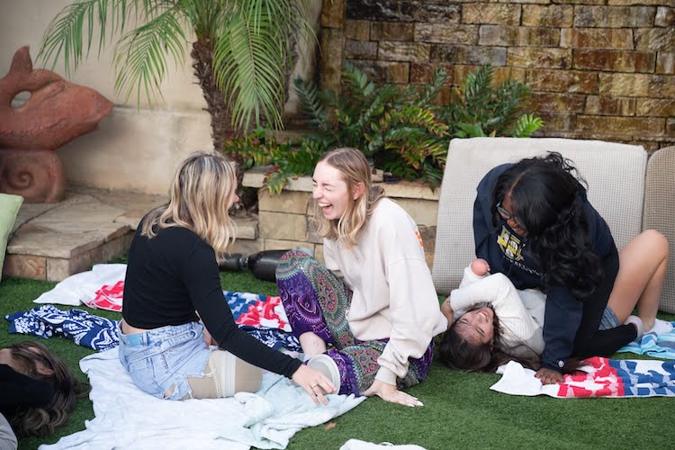 Two Beautifully Flawed attendees and leg amputees laugh together after attempting one of the maneuvers in self defense training.